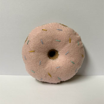 A felt donut pin cushion top view.
