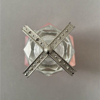 A metallic or reflective cap that contrasts with the clear glass and adds a premium feel.